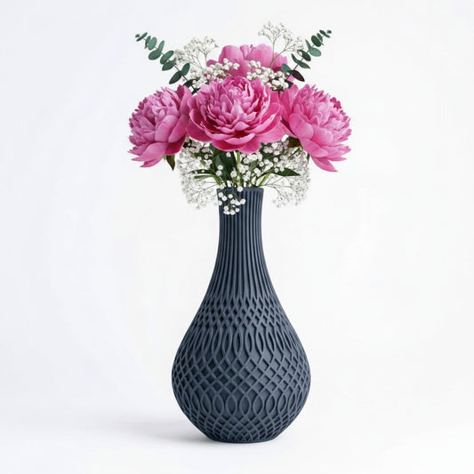 Inflect Vase in dark grey with open oval lattice pattern and slender fluted neck, styled with pink peonies and gypsophila — 3D printed decorative vase by Lux Print Labs
